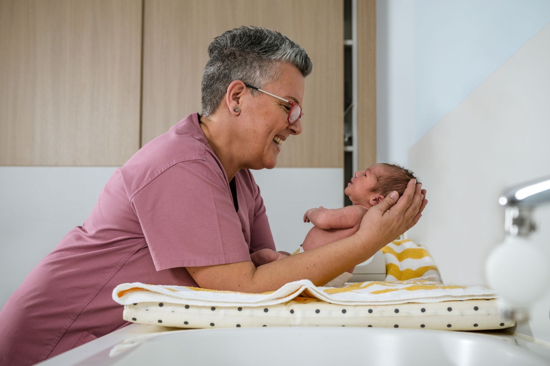 Kinderkrankenschwester hat Neugeborenes im Arm